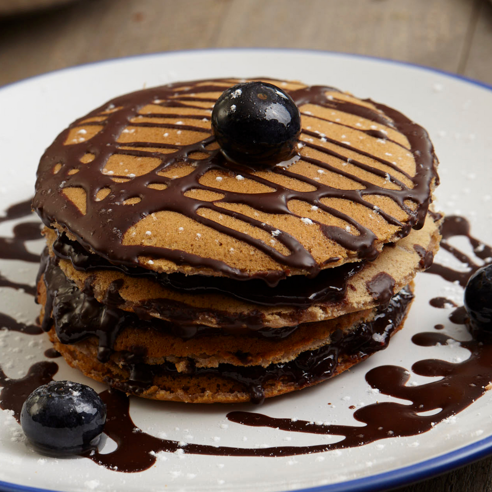 
                  
                    Panquecas com mirtilos e creme de chocolate negro são tomé com frutas portuguesas meia.dúzia
                  
                